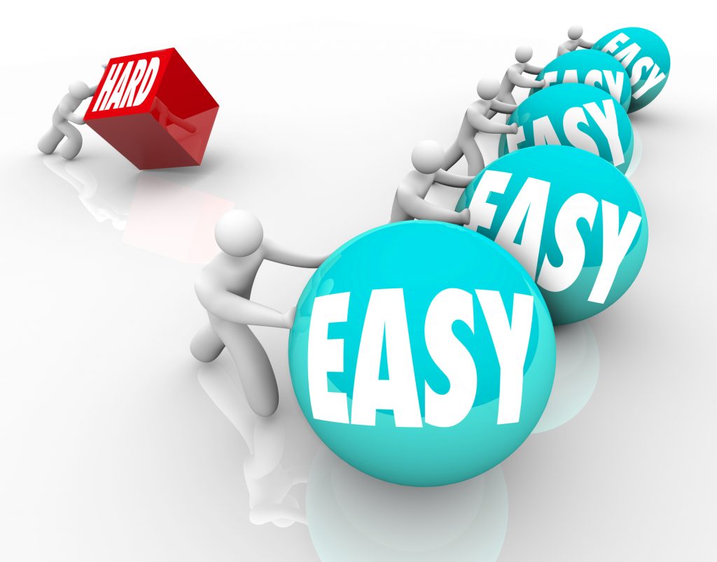 A person tries to push a cube marked Hard against many competitors easily pushing balls with the word Easy to symbolize challenge and adversity
